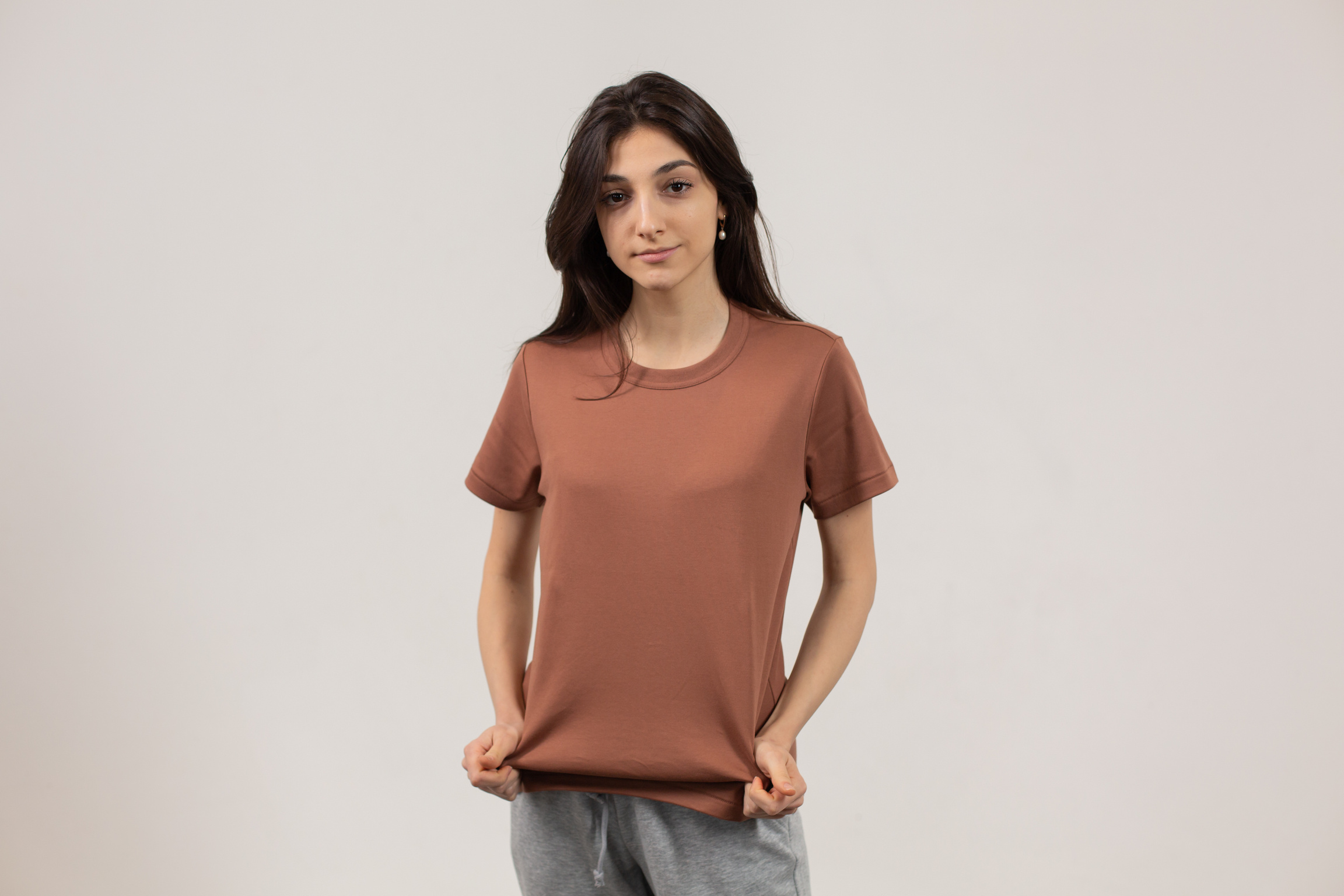 Confident ethnic lady demonstrating t shirt with hands